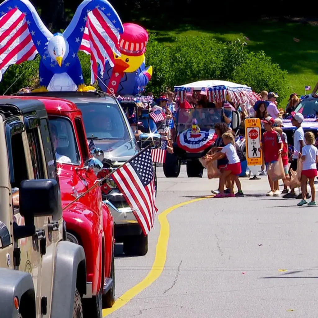 patriotic July 4th parade with American flags, decorated vehicles, and families celebrating Independence Day